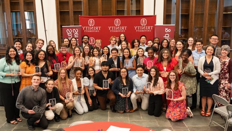 Student Leadership and Service Awards recipients and faculty and staff pose for a photo in the Korbell Great Hall