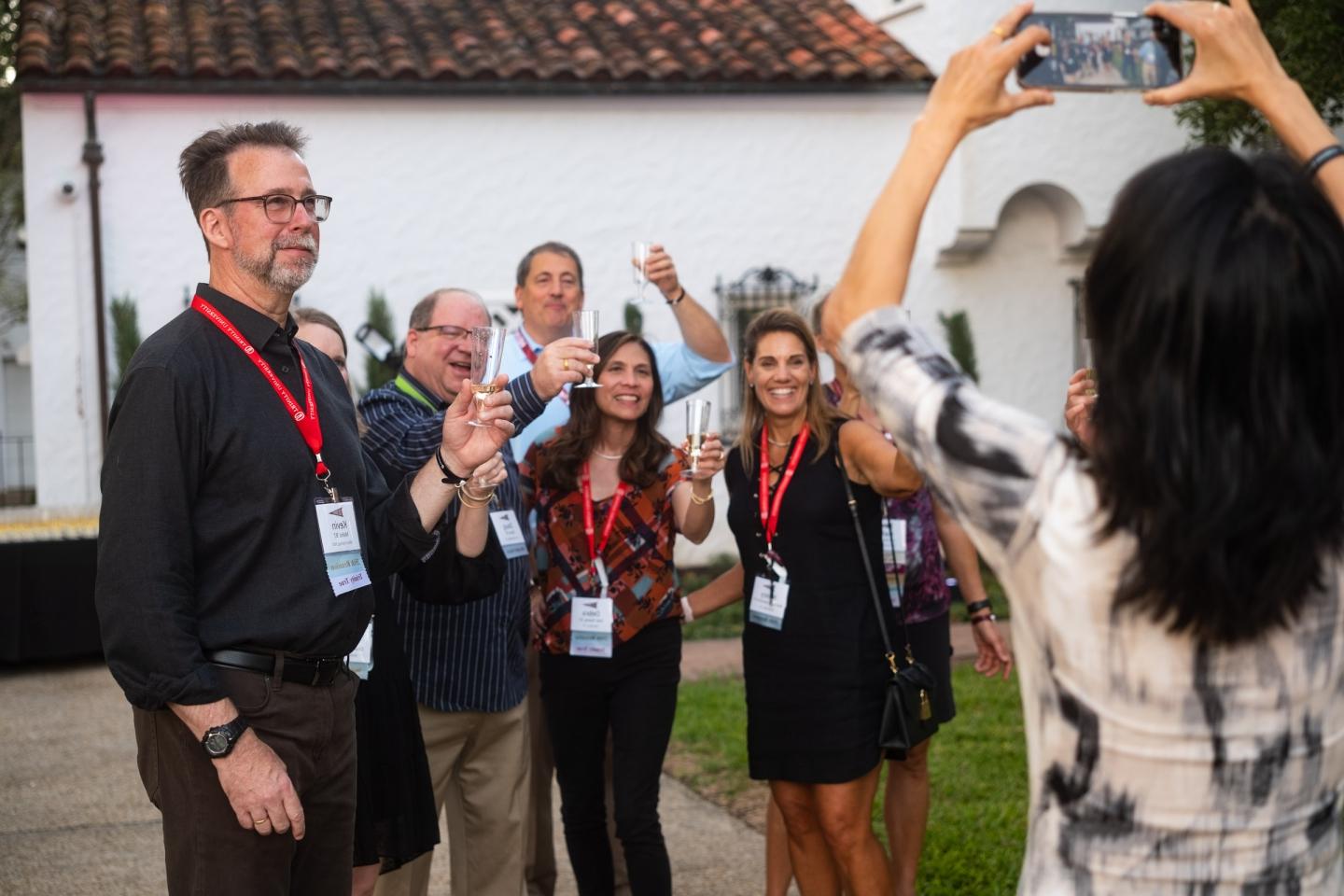 photo of alumni outside hold up wine classes and posing for a photo